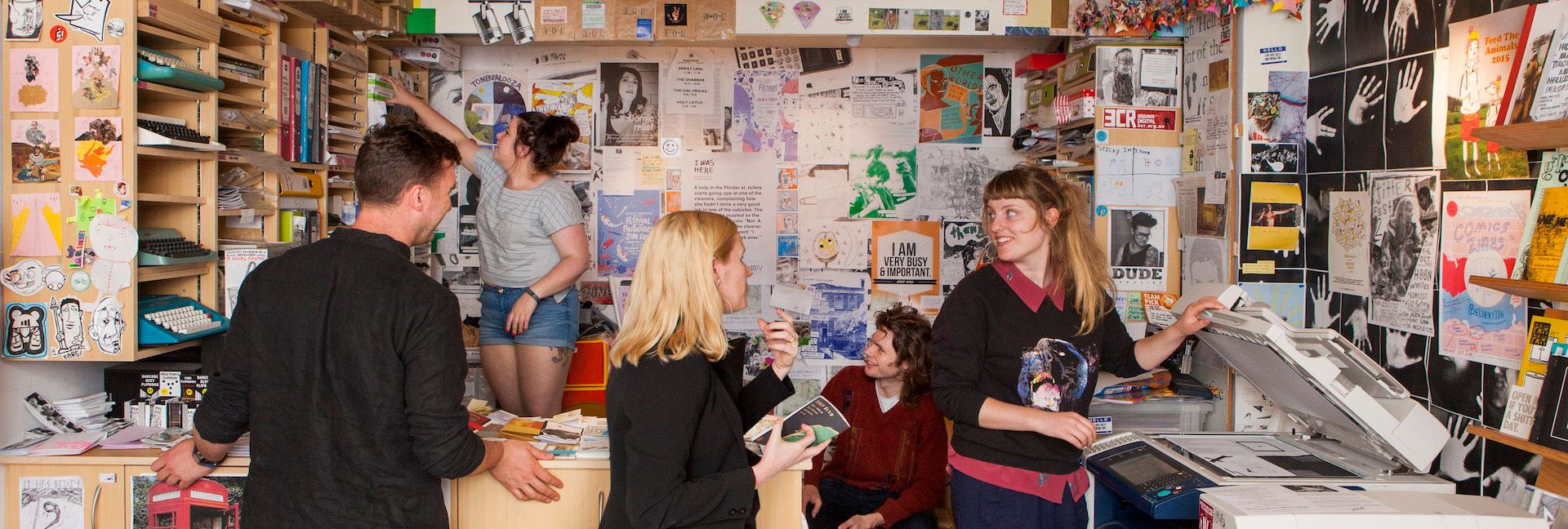 A photograph of Sticky Institute volunteers and workers chatting and working inside Sticky.